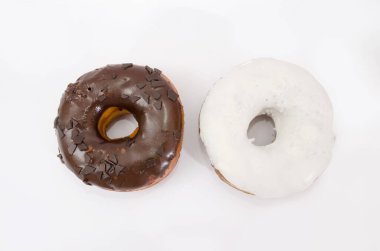 Beyaz tabakta siyah beyaz çikolata kremalı iki lezzetli çörek. Yukarıdan görüntüle.