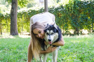 Genç güzel kız bir köpeğe sarılıyor..