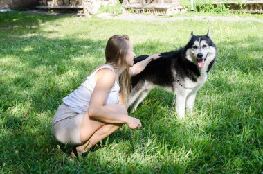 Çekici sarışın elini köpeğinin sırtına koydu..