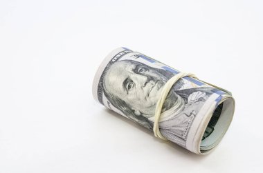 100 dolarlık banknotlar boruya bağlanmış ve elastik bir bantla bağlanmış. beyaz arkaplan, metin için boşluk kopyala