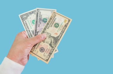İş kadınlarının elleri mavi arka planda izole edilmiş dolarları tutuyor. 5, 10.1 dolarlık banknotlar. - Uzayı kopyala