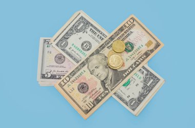 Mavi arka planda yığınla para ve para var. Finansal konsept. 1.5.10 dolarlık faturalar. Yukarıdan görüntüle