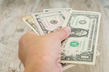 Dolarlı bir kadın eli. Dolar verme veya alma kavramı.