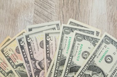 Tahta arka planda 1, 5, 10 dolarlık banknotlar. Mali konsept.