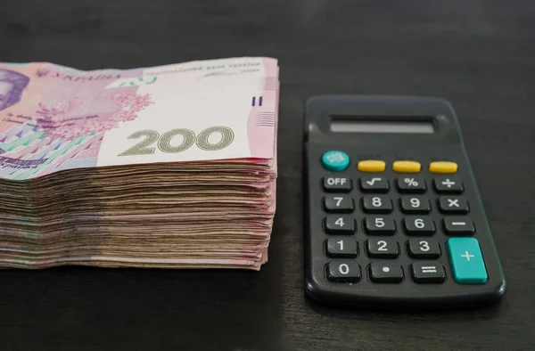 Стопка Гривен Калькулятор Черном Деревянном Фоне Украинские Деньги 200 Гривен — стоковое фото