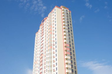 Mavi gökyüzüne karşı çok katlı bir ev.