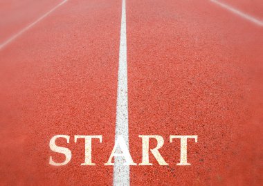 Stadyumda kırmızı koşu izleri var. Beyaz çizgi ve 