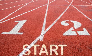 Stadyumda kırmızı koşu izleri var. Beyaz çizgi, 1 ve 2 numaralar ve 