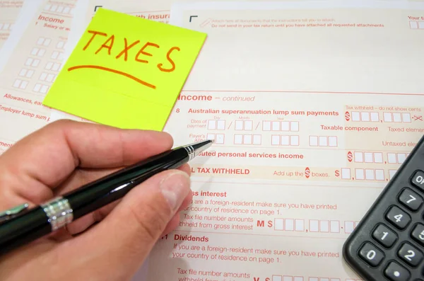 ペンで女性の手のクローズアップは オーストラリアの税務フォームを記入します 財務書類だ 税金の時間だ — ストック写真