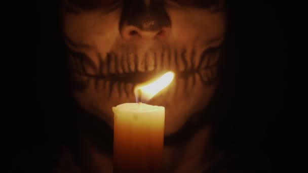 一个骨瘦如柴的男人看着摄像机 这个人很生气 施了一个咒语 骷髅在昏暗的烛光中 万圣节和恐怖概念 — 图库视频影像