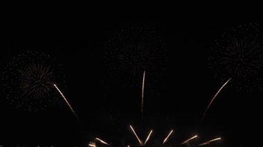 Gece gökyüzünde Bokeh ışıkları olan büyük, altın gibi havai fişekler. Parlak havai fişek gösterisi. Yeni yıl arifesi havai fişek kutlaması. Havai fişek Festivali.