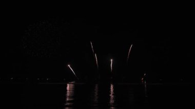 Gece gökyüzünde Bokeh ışıkları olan büyük, altın gibi havai fişekler. Parlak havai fişek gösterisi. Yeni yıl arifesi havai fişek kutlaması. Havai fişek Festivali.