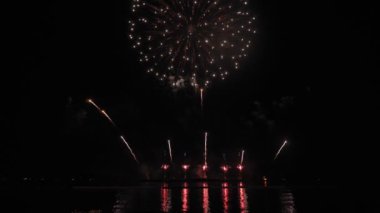Gece gökyüzünde Bokeh ışıkları olan büyük, altın gibi havai fişekler. Parlak havai fişek gösterisi. Yeni yıl arifesi havai fişek kutlaması. Havai fişek Festivali.
