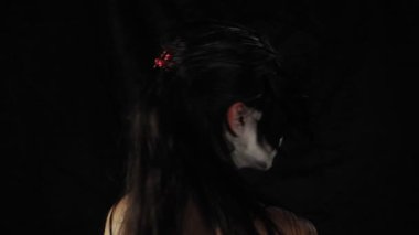 Meksika Ölüler Günü. Şeker kafalı, Cadılar Bayramı makyajlı genç bir kadın dönüp kameraya bakıyor. Mutlu Cadılar Bayramı. Yüksek kalite 4k video