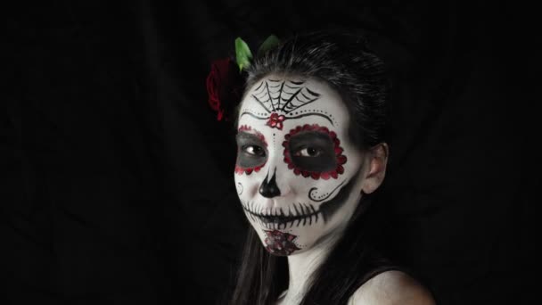 死者のメキシコの日 シュガースカルハロウィンメイクの若い女性がカメラを見ています 女は仮面を顔からはぎ取る ハロウィン 高品質4Kビデオ — ストック動画