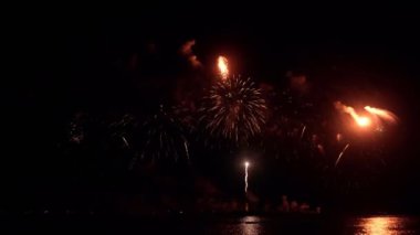 Gece gökyüzünde Bokeh ışıkları olan büyük, altın gibi havai fişekler. Parlak havai fişek gösterisi. Yeni yıl arifesi havai fişek kutlaması. Havai fişek Festivali.
