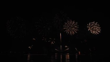 Gece gökyüzünde Bokeh ışıkları olan büyük, altın gibi havai fişekler. Parlak havai fişek gösterisi. Yeni yıl arifesi havai fişek kutlaması. Havai fişek Festivali.