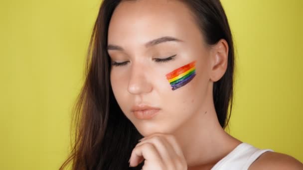 Een Vrouw Met Een Regenboog Patroon Haar Gezicht Kijkt Naar — Stockvideo