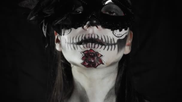 死者のメキシコの日 砂糖の頭蓋骨のハロウィーンの化粧品を持つ若い女性がカメラを見ています ハロウィン 高品質4Kビデオ — ストック動画