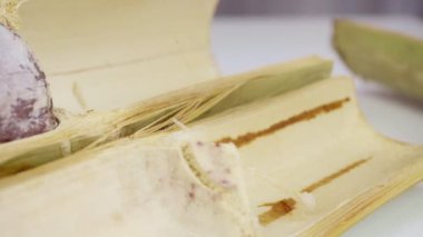 Bambu dikişlerinde kızartılmış hindistan cevizi sütü ve fasulyeli pilav. Kahverengi glutinous pilavı, ulusal bir yemek. Taylandlı ismi Khao Lam..