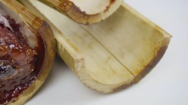 Bambu dikişlerinde kızartılmış hindistan cevizi sütü ve fasulyeli pilav. Kahverengi glutinous pilavı, ulusal bir yemek. Taylandlı ismi Khao Lam..