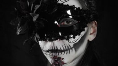 Meksika Ölüler Günü. Şeker kafalı, Cadılar Bayramı makyajlı genç bir kadın kameraya bakıyor. Mutlu Cadılar Bayramı. Yüksek kalite 4k video