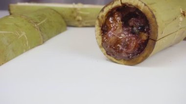 Bambu dikişlerinde kızartılmış hindistan cevizi sütü ve fasulyeli pilav. Kahverengi glutinous pilavı, ulusal bir yemek. Taylandlı ismi Khao Lam..