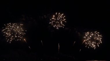 Gece gökyüzünde Bokeh ışıkları olan büyük, altın gibi havai fişekler. Parlak havai fişek gösterisi. Yeni yıl arifesi havai fişek kutlaması. Havai fişek Festivali.