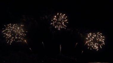 Gece gökyüzünde Bokeh ışıkları olan büyük, altın gibi havai fişekler. Parlak havai fişek gösterisi. Yeni yıl arifesi havai fişek kutlaması. Havai fişek Festivali.