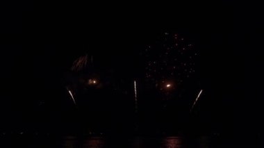 Gece gökyüzünde Bokeh ışıkları olan büyük, altın gibi havai fişekler. Parlak havai fişek gösterisi. Yeni yıl arifesi havai fişek kutlaması. Havai fişek Festivali.