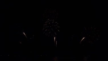 Gece gökyüzünde Bokeh ışıkları olan büyük, altın gibi havai fişekler. Parlak havai fişek gösterisi. Yeni yıl arifesi havai fişek kutlaması. Havai fişek Festivali.