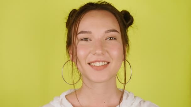 幸せな女性は カメラを見て 孤立した黄色の背景の上に笑顔 高品質4K映像 — ストック動画