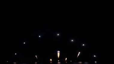 Gece gökyüzünde Bokeh ışıkları olan büyük, altın gibi havai fişekler. Parlak havai fişek gösterisi. Yeni yıl arifesi havai fişek kutlaması. Havai fişek Festivali.