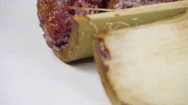 Bambu dikişlerinde kızartılmış hindistan cevizi sütü ve fasulyeli pilav. Kahverengi glutinous pilavı, ulusal bir yemek. Taylandlı ismi Khao Lam..