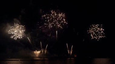 Gece gökyüzünde Bokeh ışıkları olan büyük, altın gibi havai fişekler. Parlak havai fişek gösterisi. Yeni yıl arifesi havai fişek kutlaması. Havai fişek Festivali.