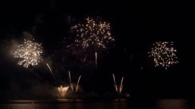 Gece gökyüzünde Bokeh ışıkları olan büyük, altın gibi havai fişekler. Parlak havai fişek gösterisi. Yeni yıl arifesi havai fişek kutlaması. Havai fişek Festivali.