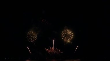 Gece gökyüzünde Bokeh ışıkları olan büyük, altın gibi havai fişekler. Parlak havai fişek gösterisi. Yeni yıl arifesi havai fişek kutlaması. Havai fişek Festivali.