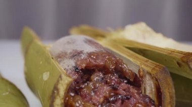 Bambu dikişlerinde kızartılmış hindistan cevizi sütü ve fasulyeli pilav. Kahverengi glutinous pilavı, ulusal bir yemek. Taylandlı ismi Khao Lam..