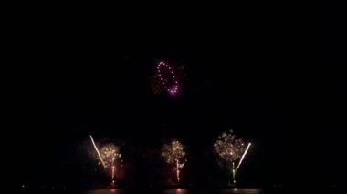 Gece gökyüzünde Bokeh ışıkları olan büyük, altın gibi havai fişekler. Parlak havai fişek gösterisi. Yeni yıl arifesi havai fişek kutlaması. Havai fişek Festivali.
