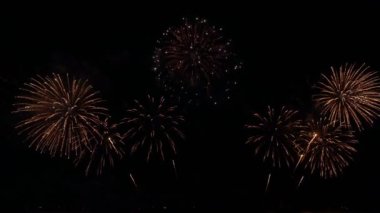 Gece gökyüzünde Bokeh ışıkları olan büyük, altın gibi havai fişekler. Parlak havai fişek gösterisi. Yeni yıl arifesi havai fişek kutlaması. Havai fişek Festivali.