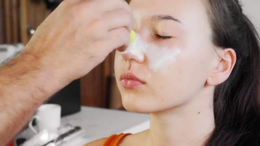 Ressam bayramdan önce bir kıza makyaj yapar. Bir adam bir yüz çizer. Mutlu Cadılar Bayramı