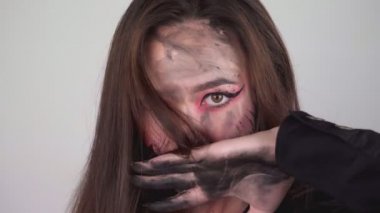 Seksi kadın yüzünün her yerine boya bulaştırıyor. Cadılar bayramı için makyajı yıkayan kadın. Yüksek kalite 4k görüntü