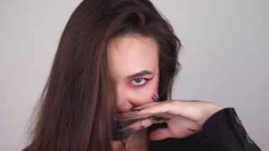 Seksi kadın yüzünün her yerine boya bulaştırıyor. Cadılar bayramı için makyajı yıkayan kadın. Yüksek kalite 4k görüntü