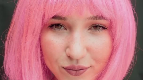 Close-up seorang wanita dengan rambut merah muda menatap kamera. — Stok Video