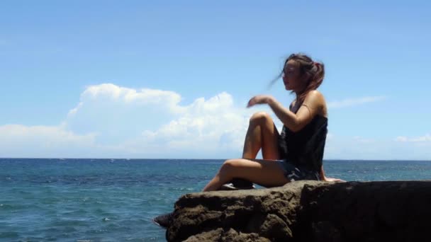 Jovem Mulher Senta Uma Rocha Desfruta Sol Mar Dia Quente — Vídeo de Stock