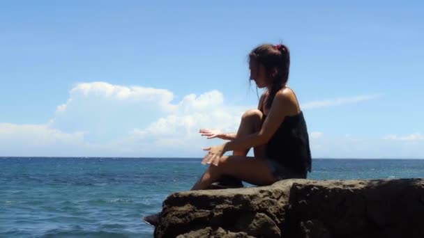 Jovem Mulher Senta Uma Rocha Desfruta Sol Mar Dia Quente — Vídeo de Stock