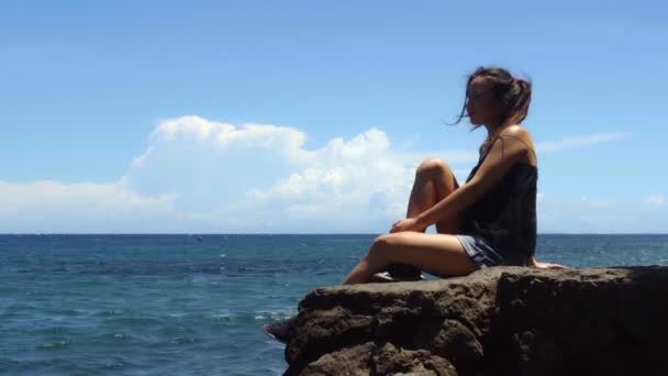 Молодая Женщина Сидит Скале Наслаждается Солнцем Морем Жаркий День Высококачественные — стоковое видео