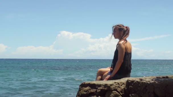 Jovem Mulher Senta Uma Rocha Desfruta Sol Mar Dia Quente — Vídeo de Stock