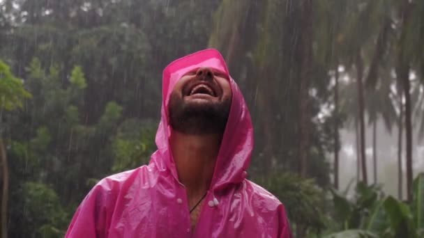 Homme Adulte Imperméable Rose Profite Pluie Tropicale Ralenti Des Images — Video