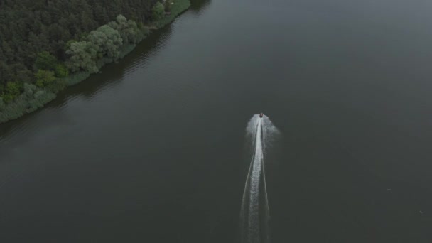 L'uomo guida una moto d'acqua sul fiume con un ponte, vista aerea — Video Stock